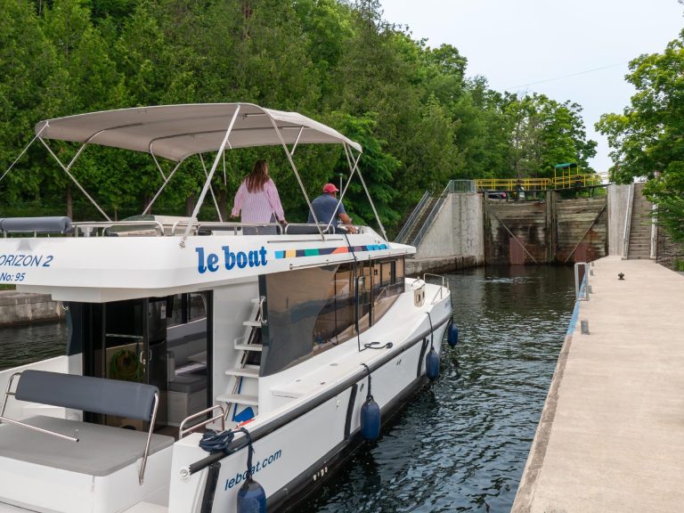 A Le Boat houseboat waits in front of the doors of a lock
