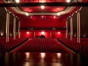 Plush red seats of a large theatre