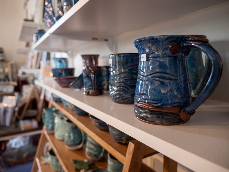 Row of handmade blue ceramic mugs