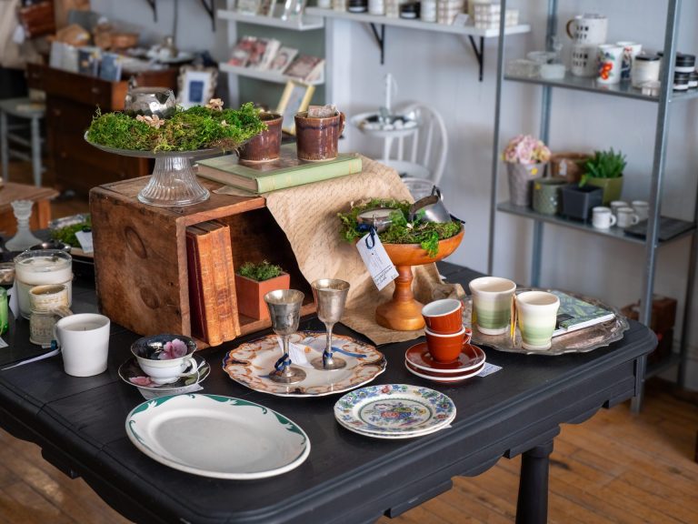 Vintage shop entryway display, featuring decorative plates and cups