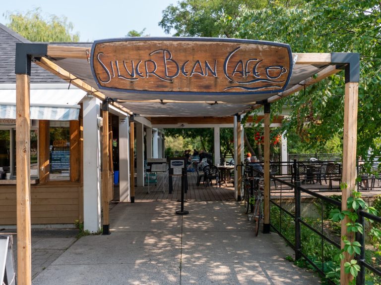 Sign reading Silver Bean Cafe, over entrance to a cafe patio
